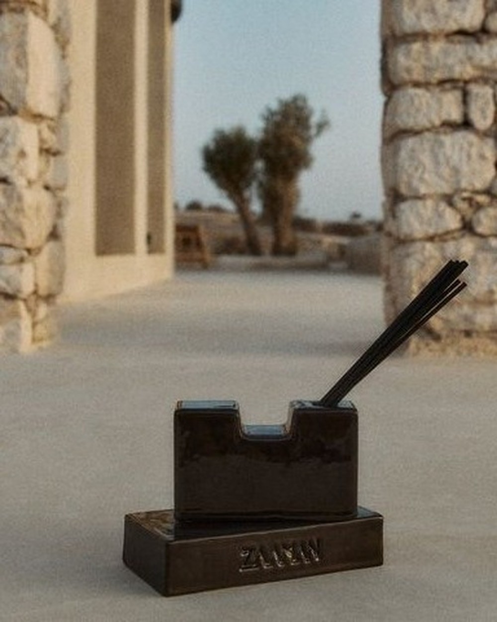 Black Zaaman Sandcastle ceramic vessel, stone archway courtyard